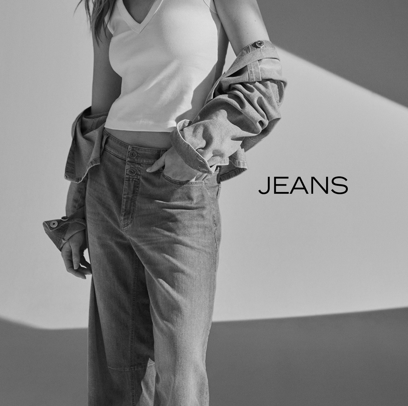 Model wearing light wide-leg jeans with a relaxed overshirt – teaser for Rosner Studio’s jeans category.