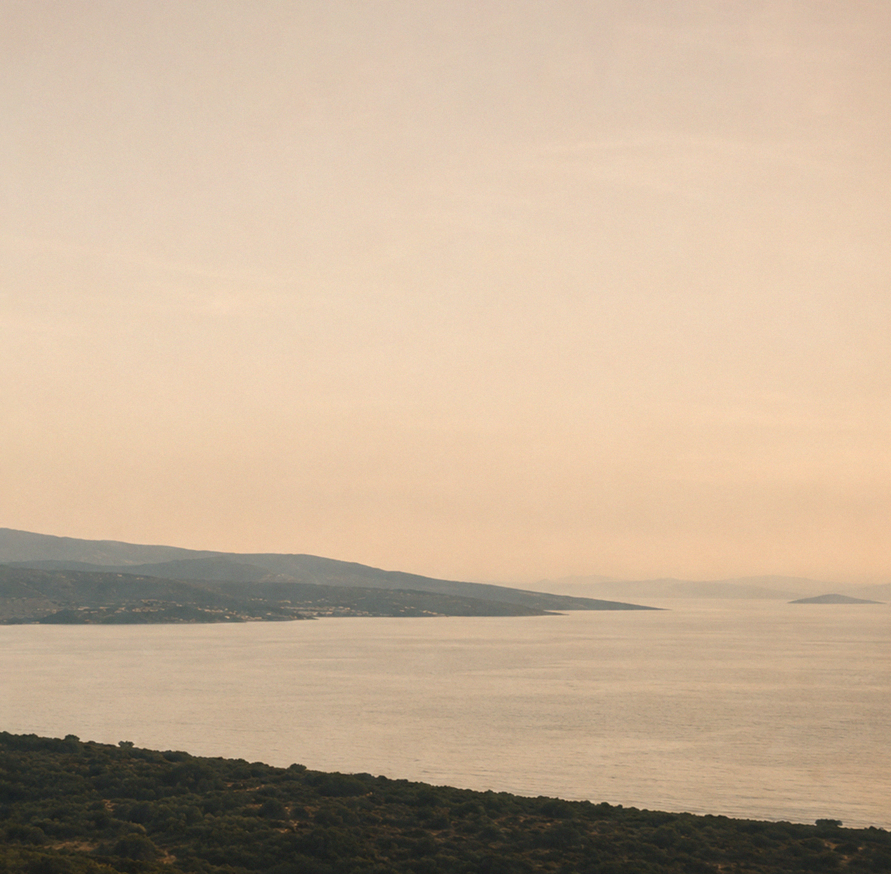 Expansive coastal landscape with sea and mountains in warm light – hero teaser for the ROSNER Studio Sale