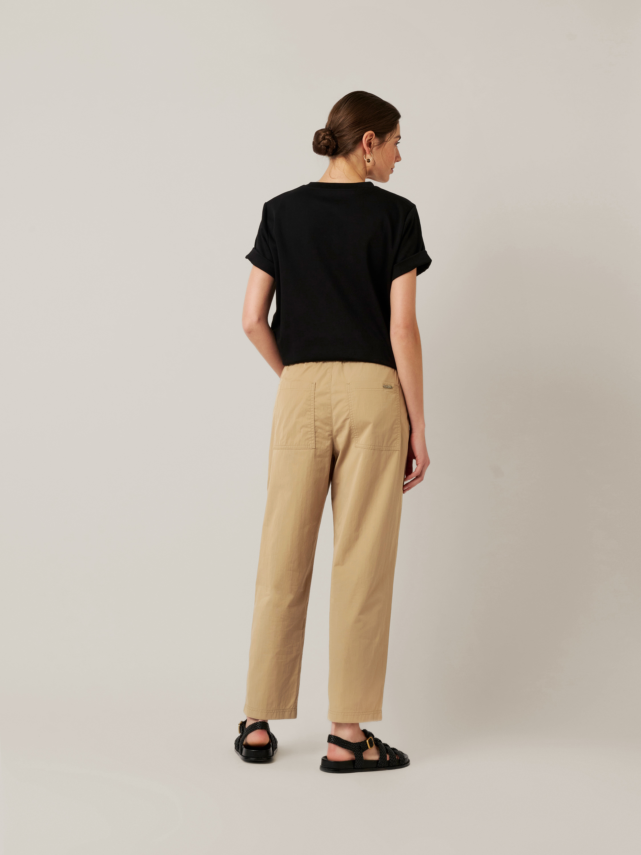 Womens trousers Mara Pocket in sand, relaxed trousers with front pockets, back view worn by model