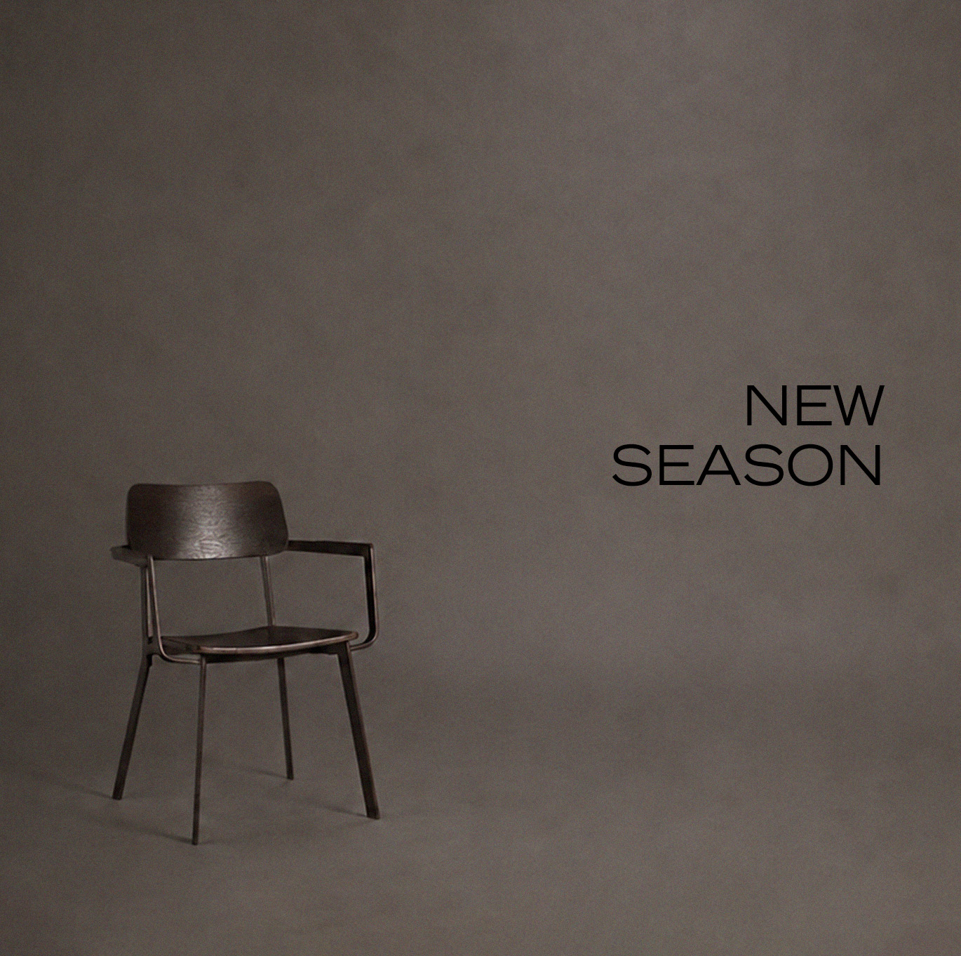 Freestanding dark chair against a grey background – hero teaser for the new ROSNER collection