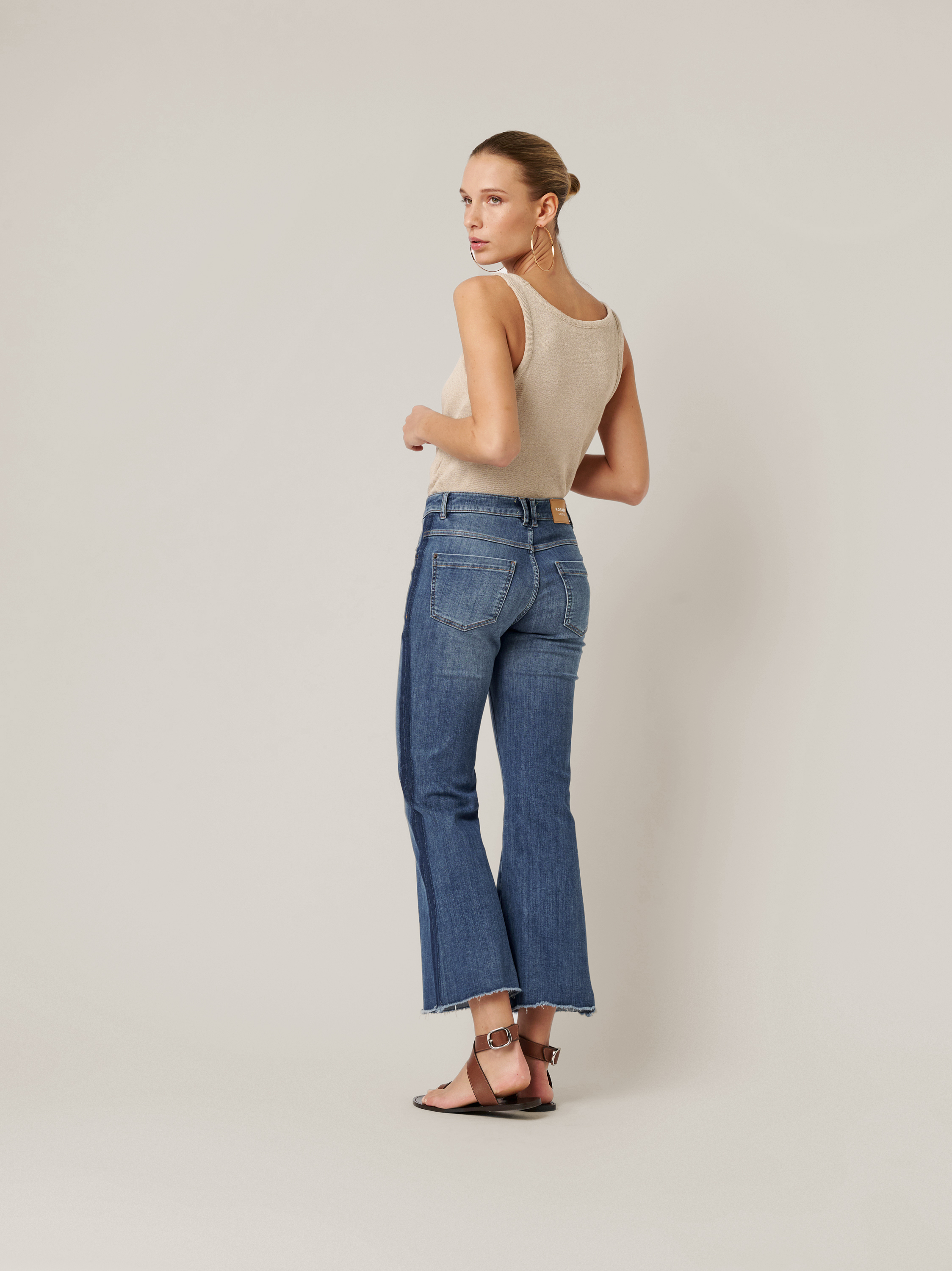 Womens jeans Antonia Bootcut in mid blue, jeans with raw hems and side stripes, back view worn by model