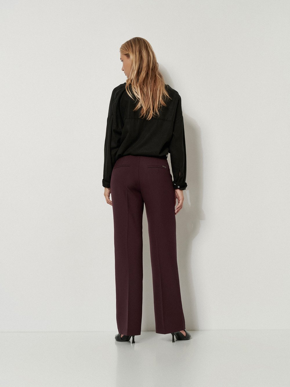 Damenhose Audrey Flared in Bordeaux, flared-Hose mit Tailoring-Details, Rueckansicht am Model getragen