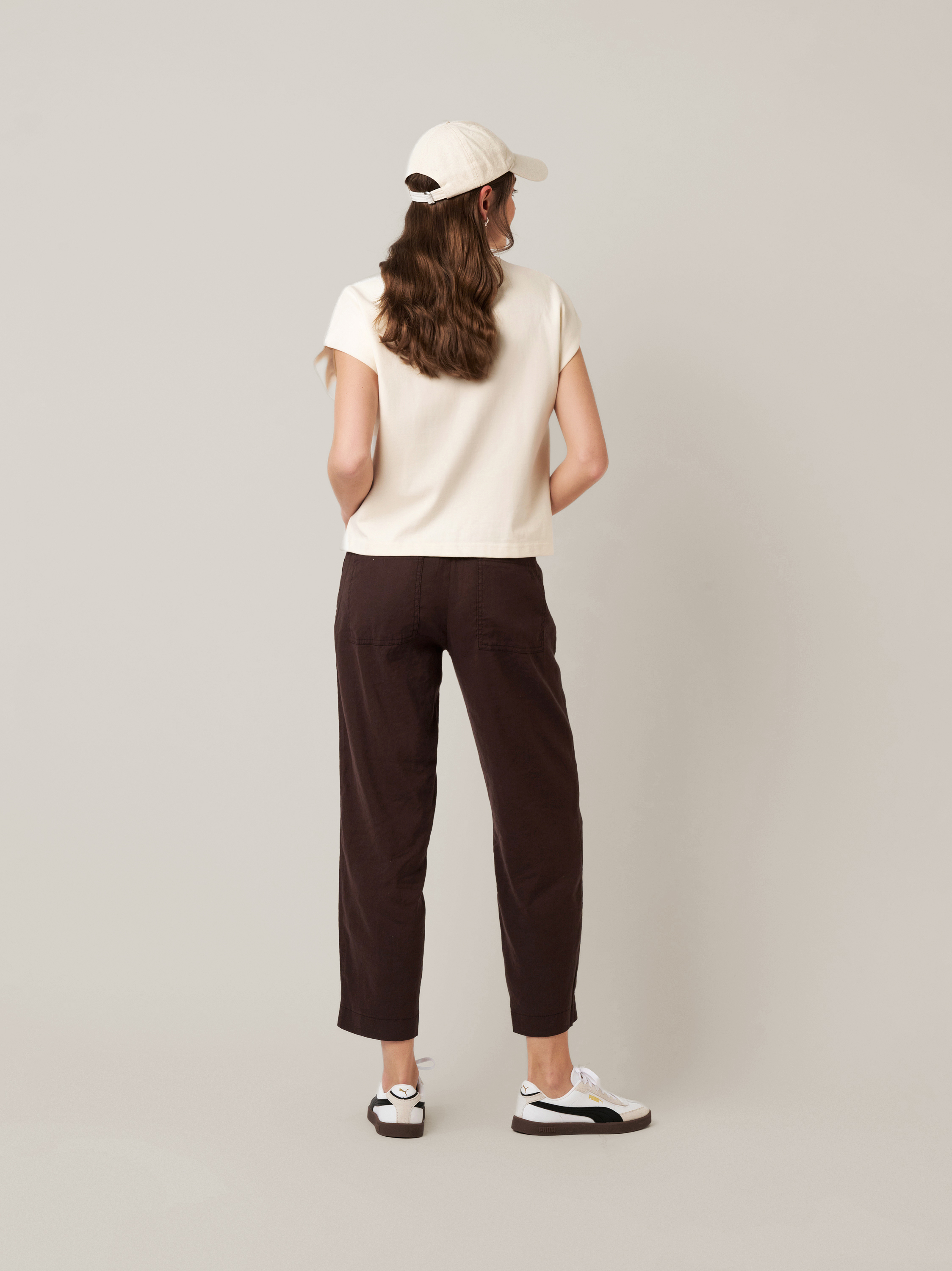 Womens trousers Mara Tapered in dark brown, tapered-fit trousers made of linen, back view worn by model