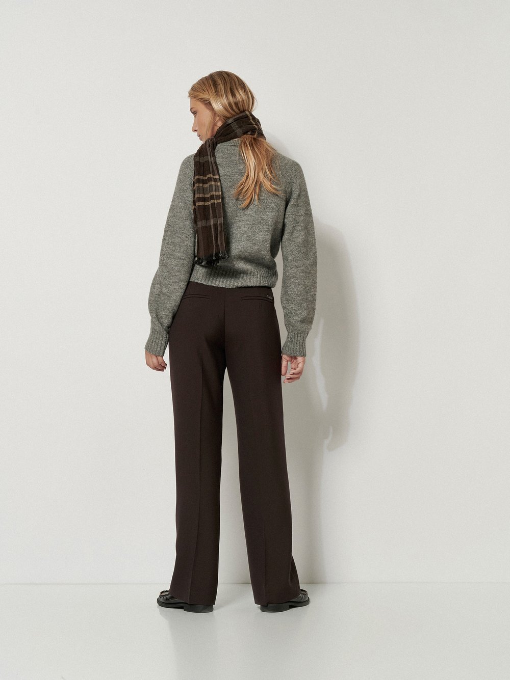 Damenhose Audrey Flared in Dunkelbraun, flared-Hose mit Tailoring-Details, Rueckansicht am Model getragen