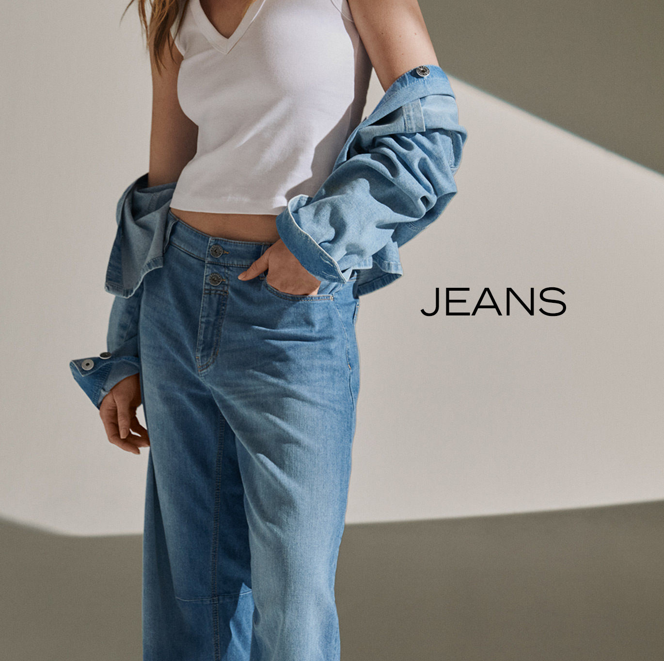 Woman wearing light blue wide-leg jeans and denim overshirt – teaser for Rosner Studio’s jeans category.