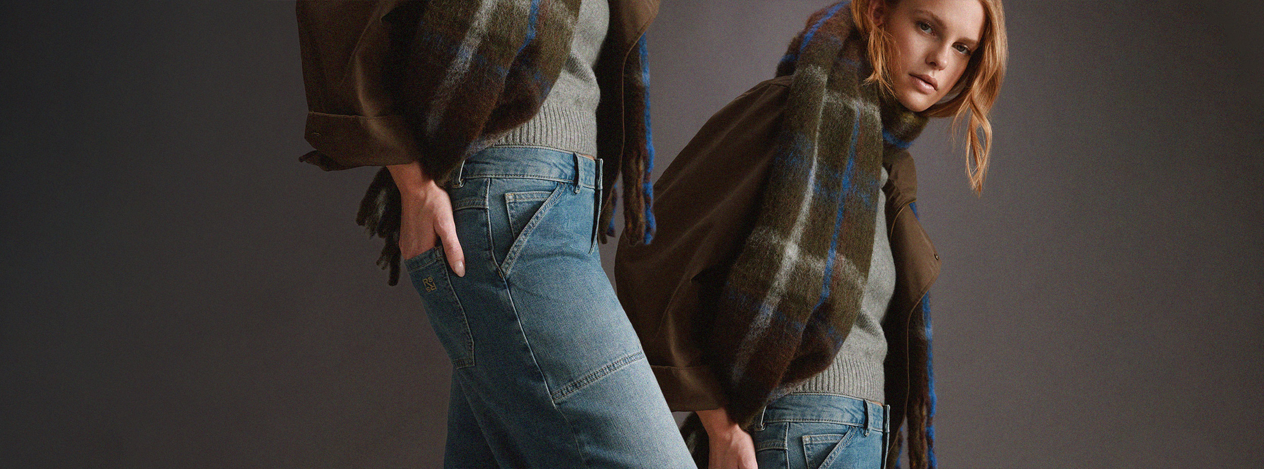 Rosner campaign featuring a model in light-wash jeans, grey knitwear, a brown jacket and a statement checked scarf.