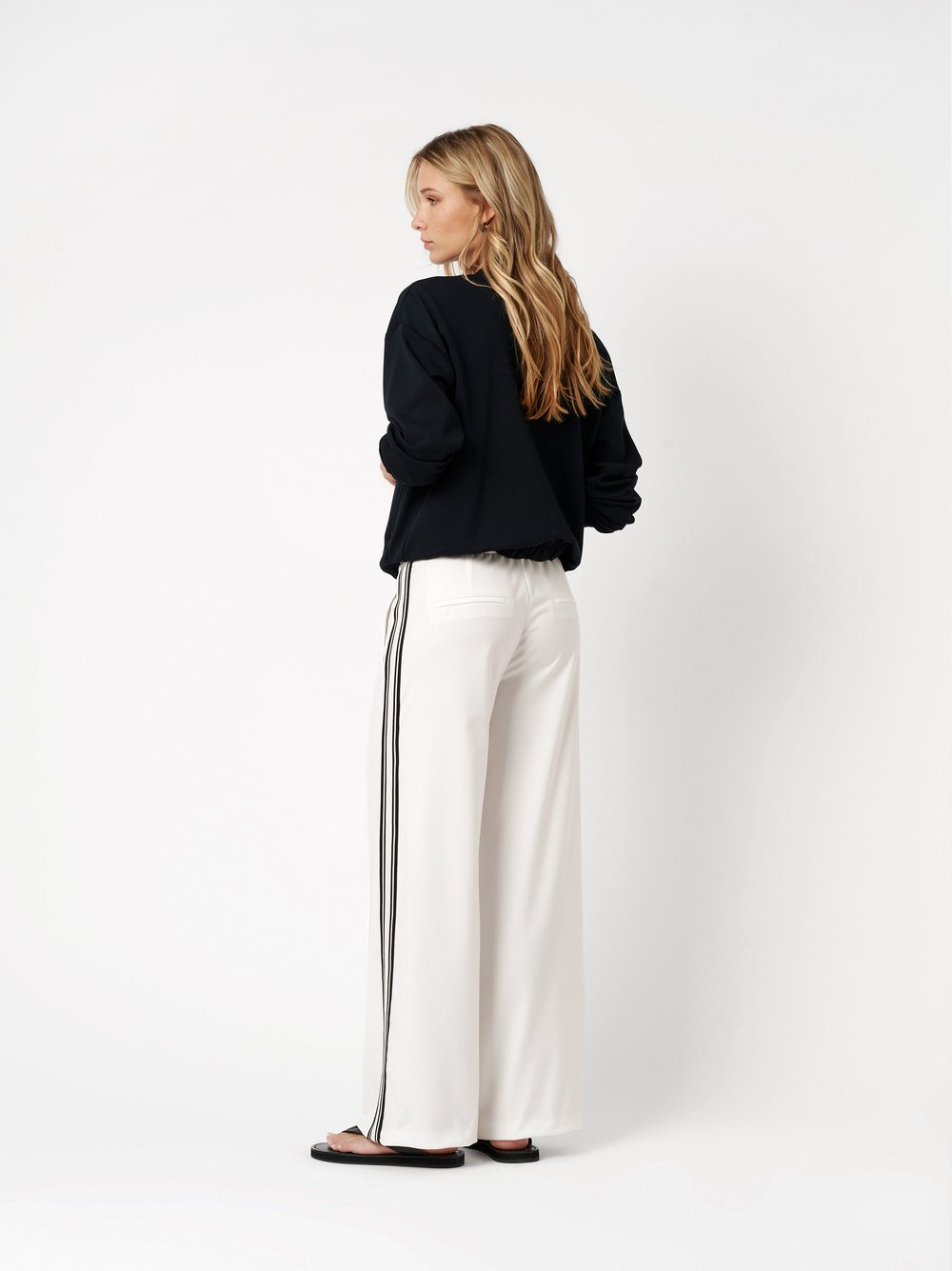 Damenhose May Wide in white, Wide Leg Hose mit Galonstreifen, Rueckansicht am Model getragen